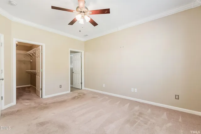 an empty room with closet and a chandelier fan