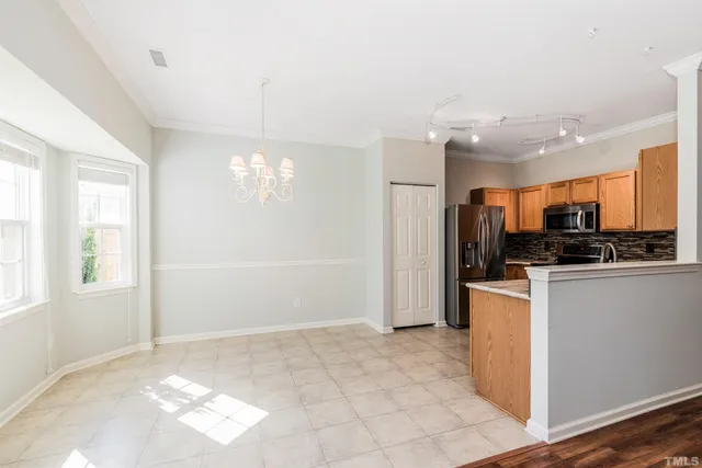 a view of kitchen with stainless steel appliances granite countertop a refrigerator and a stove top oven