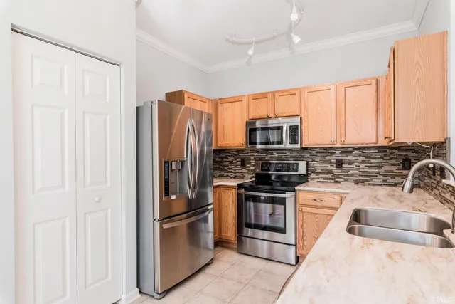 a kitchen with stainless steel appliances granite countertop a refrigerator stove and sink