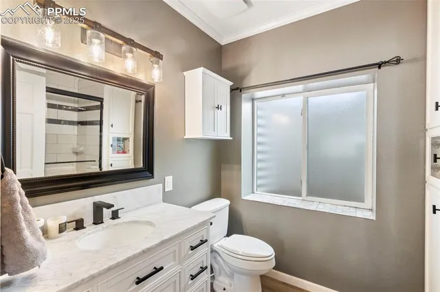 a bathroom with a granite countertop sink mirror vanity and toilet