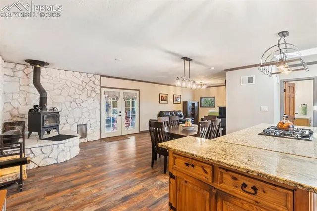 a view of a dining room and livingroom with furniture wooden floor a chandelier
