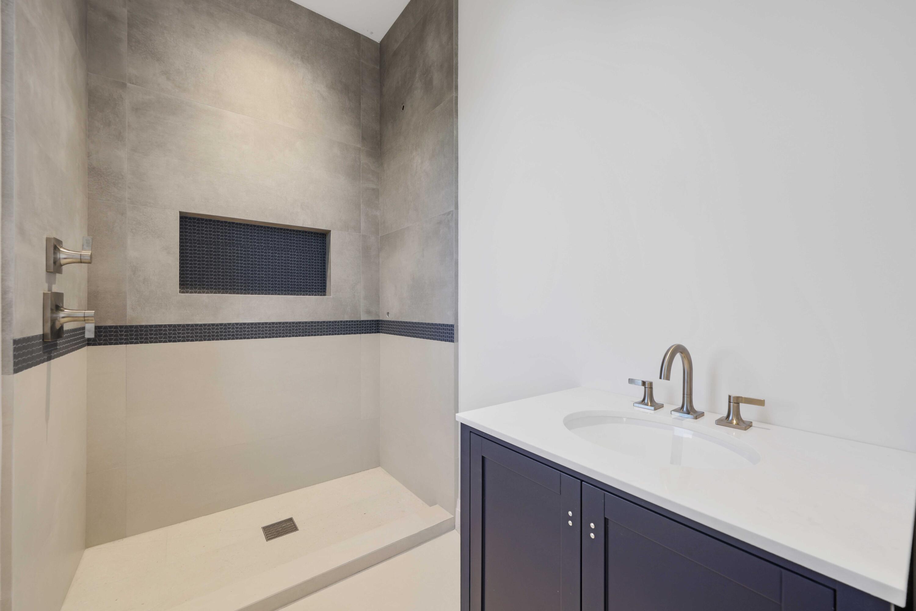 810 Northeast 70th Street Boca Raton, FL 33487 - Photo 30 of 32 a bathroom with a sink a shower and a mirror