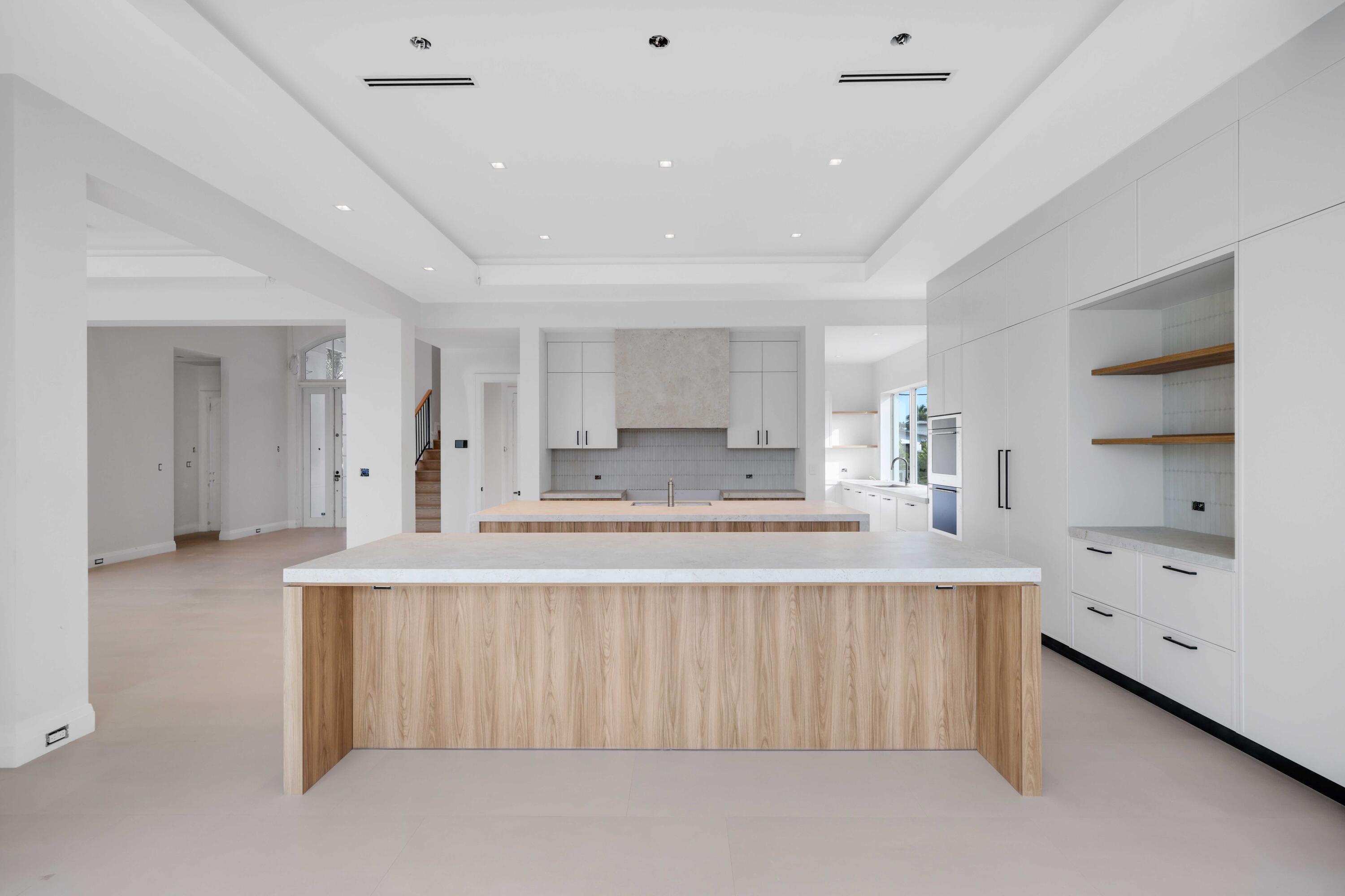 810 Northeast 70th Street Boca Raton, FL 33487 - Photo 6 of 32 a large white kitchen with kitchen island a sink white cabinets and stainless steel appliances