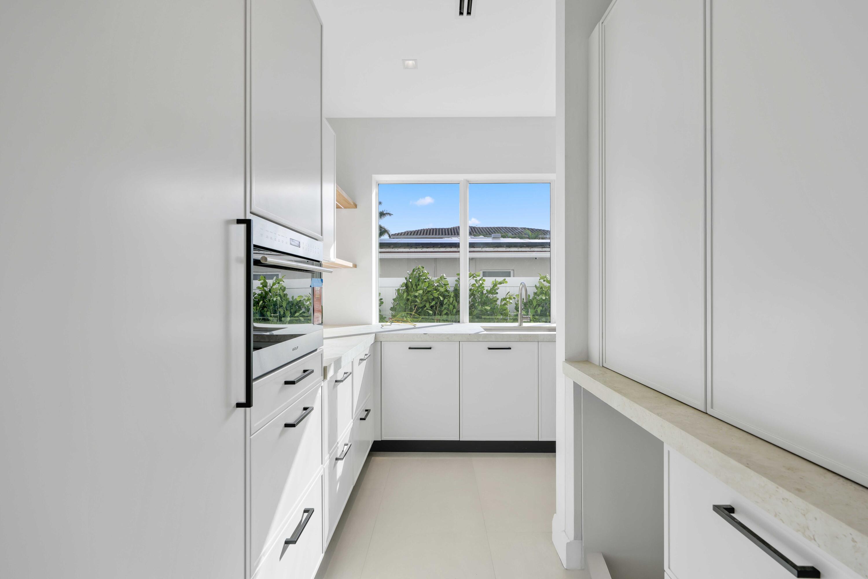 810 Northeast 70th Street Boca Raton, FL 33487 - Photo 10 of 32 a kitchen with white cabinets and white appliances