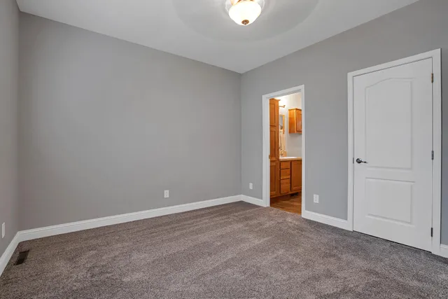 an empty room with closet and windows