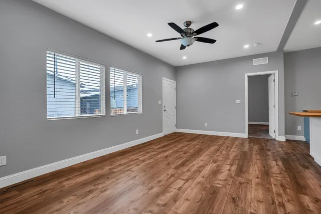 a view of a livingroom with a ceiling fan and wooden floor
