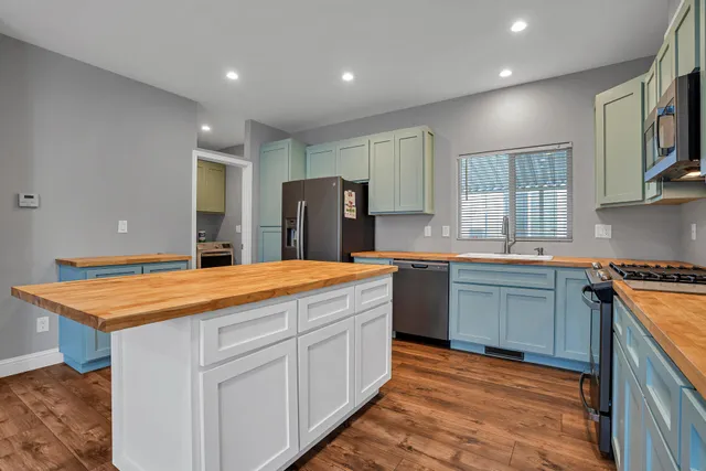 a kitchen with stainless steel appliances granite countertop refrigerator sink and cabinets