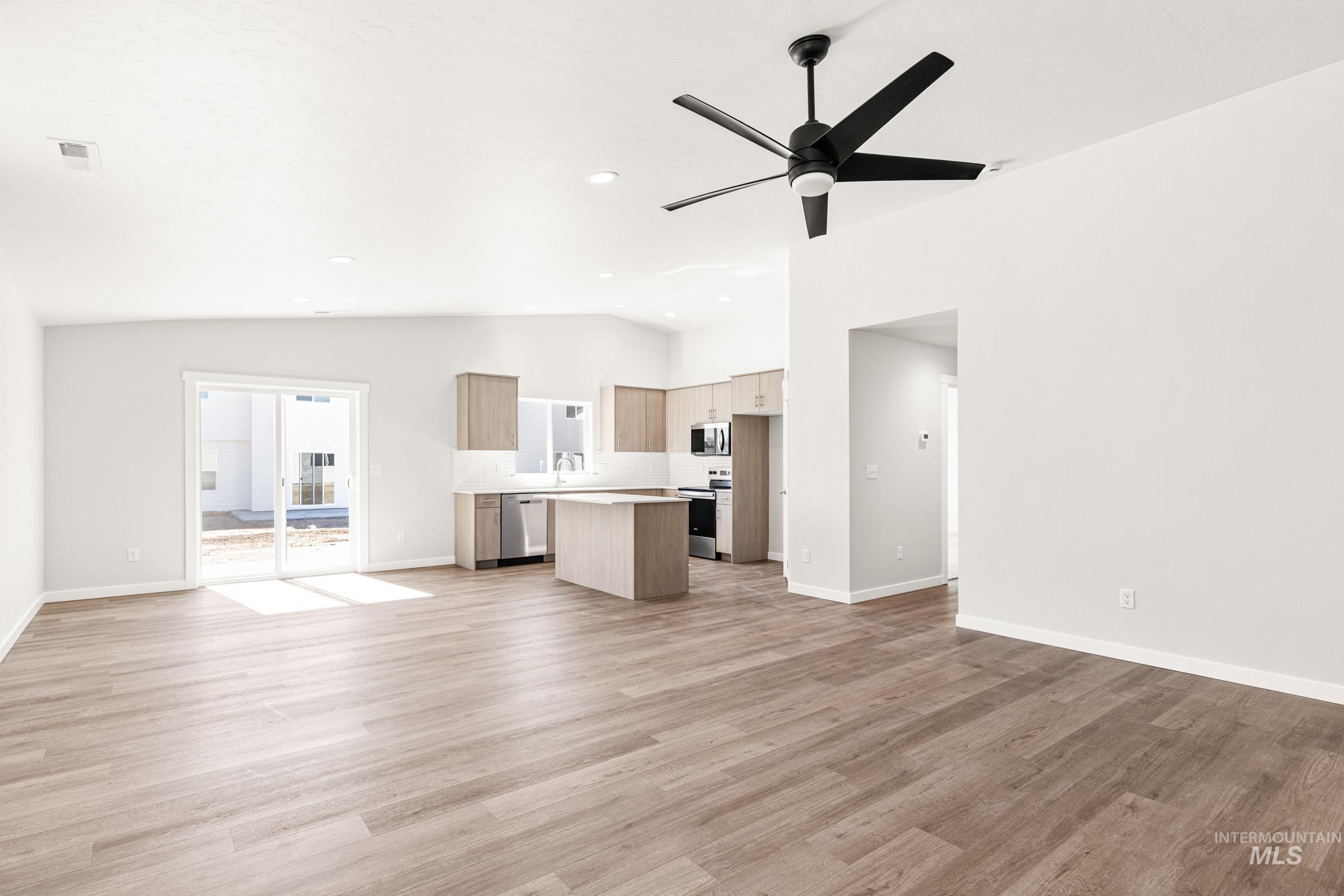 1077 West Jasper Street Meridian, ID 83642 - Photo 10 of 19 Open-concept living space featuring wood-finish flooring, a modern black ceiling fan, recessed lighting, and a sliding glass door