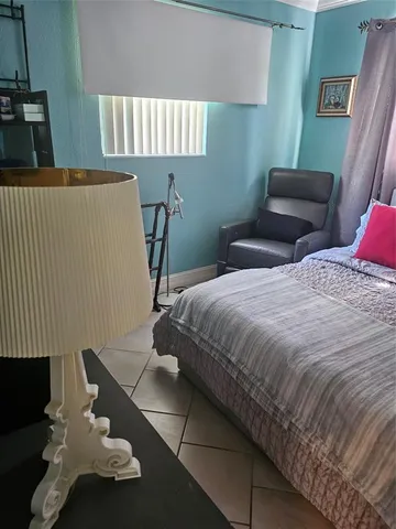 a room with a bed and a flat tv screen on dresser