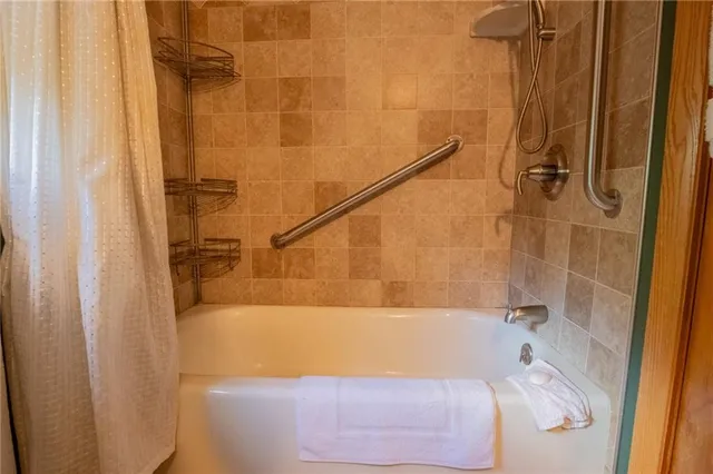 an empty room with a chandelier fan and windows