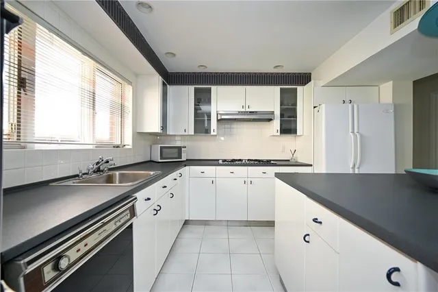a kitchen with granite countertop a sink stove and cabinets