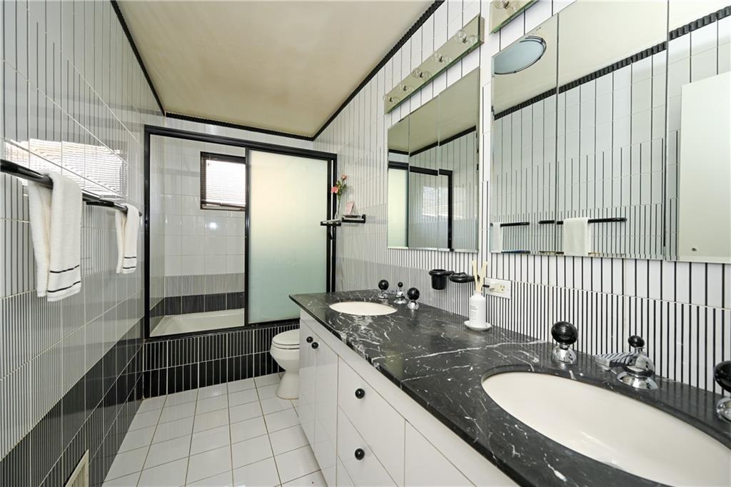 29 Kansas Place Brooklyn, NY 11234 - Photo 10 of 24 a bathroom with a granite countertop double vanity sink a mirror and a shower