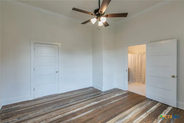 a view of a livingroom with wooden floor and a ceiling fan