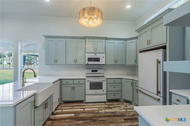 a kitchen with kitchen island granite countertop a stove and a sink