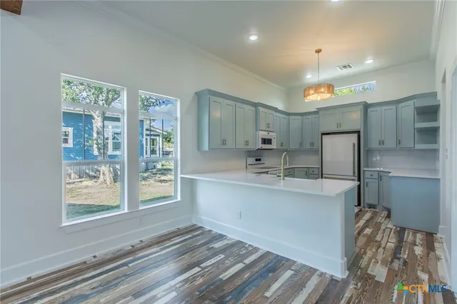 a kitchen with stainless steel appliances granite countertop a sink window and a refrigerator