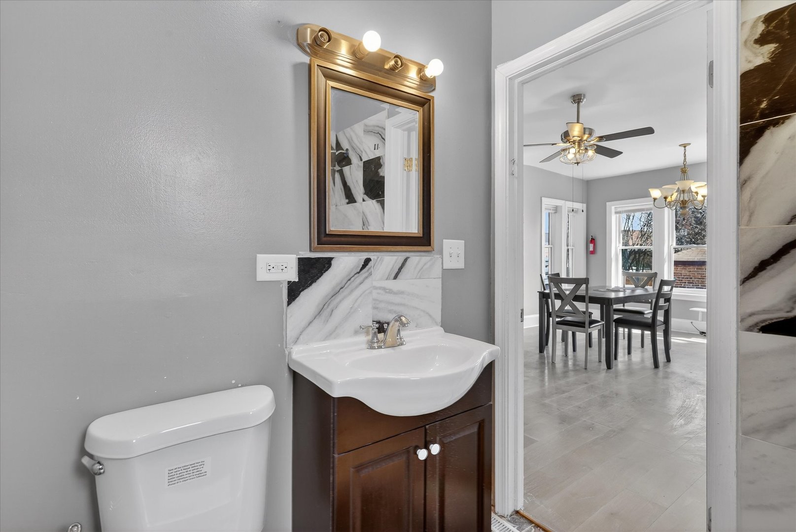1 East 114th Street Chicago, IL 60628 - Photo 24 of 33 a bathroom with a toilet a sink and mirror