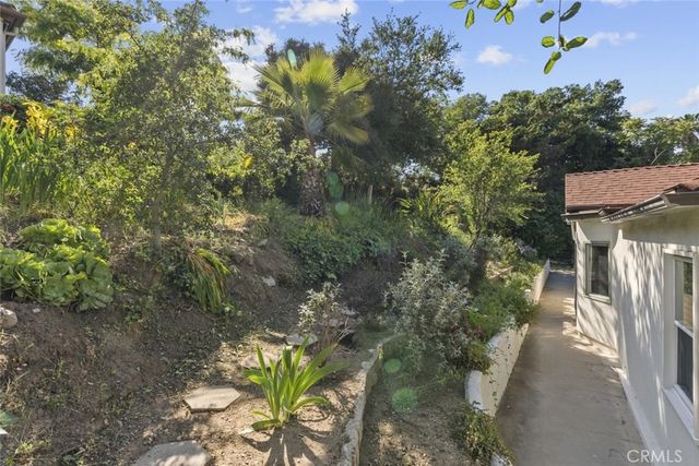 a view of backyard with a table and chairs and potted plants