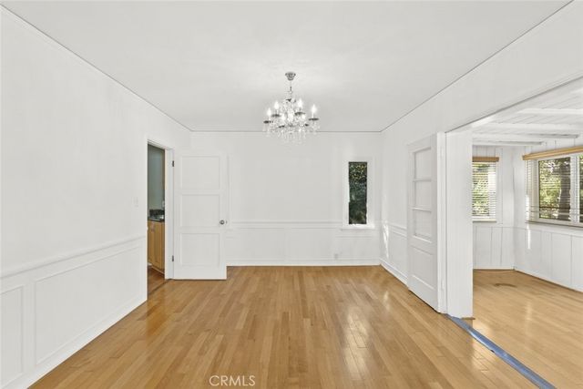 a view of a room with wooden floor and chandelier
