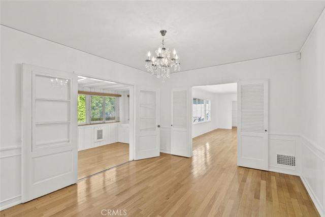 a view of a livingroom with wooden floor and a chandelier