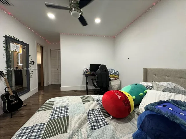 a spacious bedroom with a bed and wooden floor