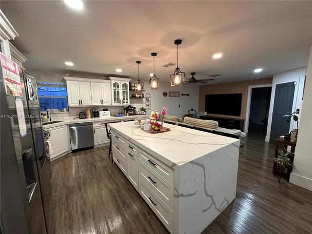 a large kitchen with lots of counter space and stainless steel appliances
