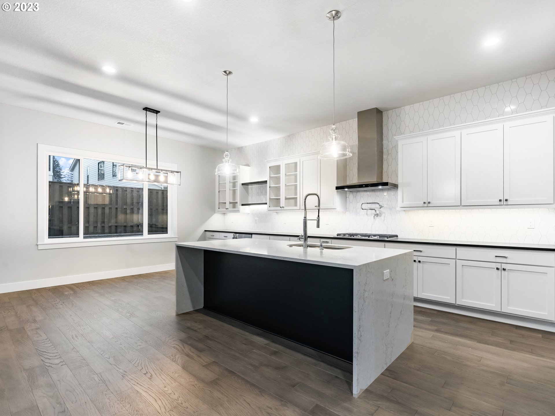 16084 Northwest Ridgeline Street, Unit L 72 Portland, OR 97229 - Photo 3 of 25 a kitchen with stainless steel appliances granite countertop a sink a stove a kitchen island with wooden cabinets and floors