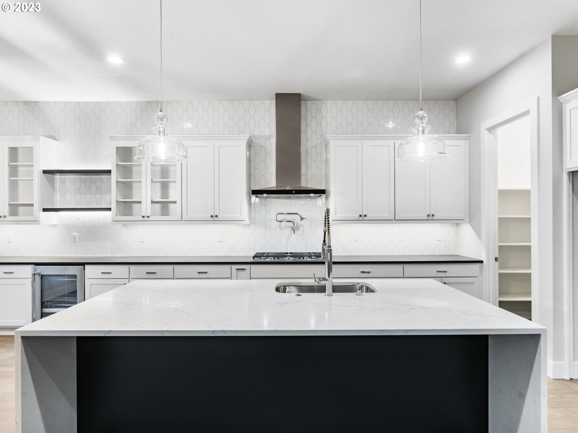 16084 Northwest Ridgeline Street, Unit L 72 Portland, OR 97229 - Photo 7 of 25 a kitchen with kitchen island a sink stainless steel appliances and cabinets