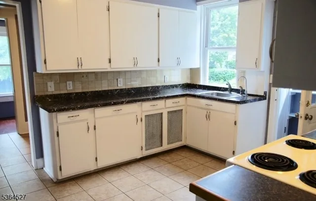 a kitchen with granite countertop white cabinets and white appliances