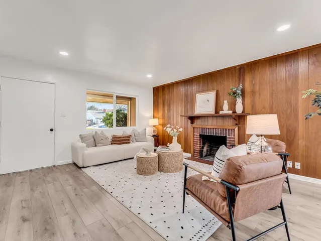 a living room with furniture a fireplace and a large window