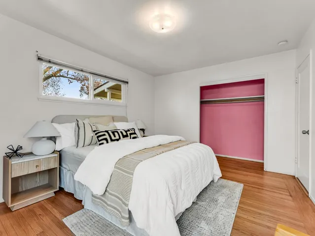 a bedroom with bed and wooden floor