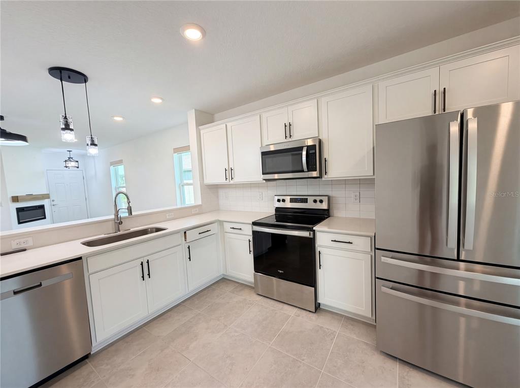 8359 Southwest 54th Street Ocala, FL 34481 - Photo 11 of 26 a kitchen with a refrigerator sink and white cabinets