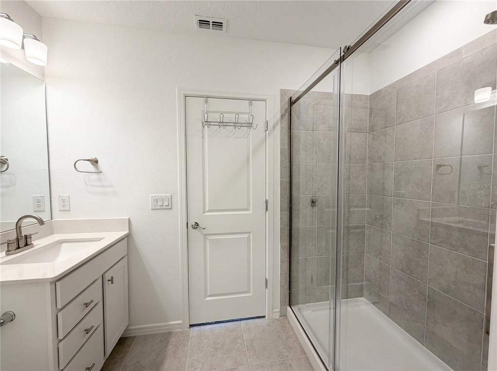 8359 Southwest 54th Street Ocala, FL 34481 - Photo 18 of 26 a bathroom with a shower sink vanity and mirror