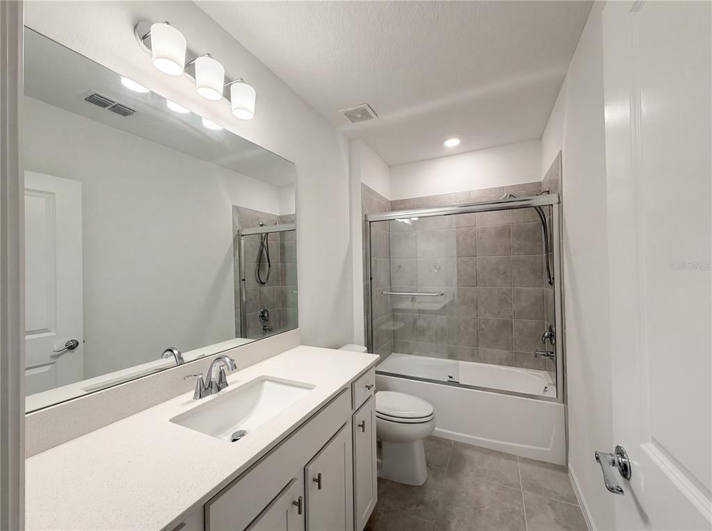 8359 Southwest 54th Street Ocala, FL 34481 - Photo 21 of 26 a bathroom with a shower sink vanity mirror and toilet