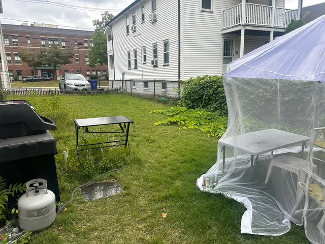 a view of a chair and table in backyard of the house