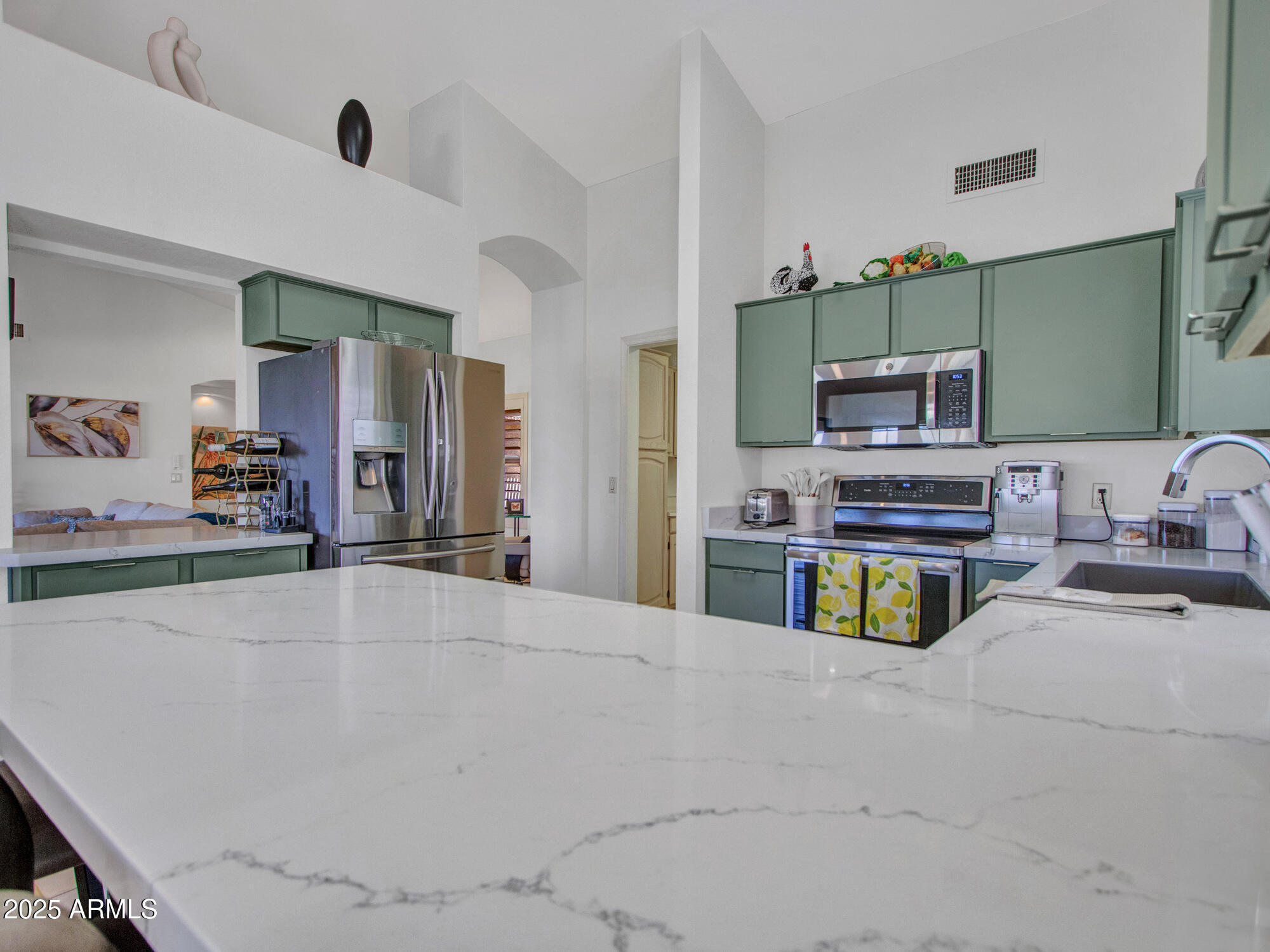9343 West Escuda Drive Peoria, AZ 85382 - Photo 11 of 51 a kitchen with kitchen island a counter top space a sink and a refrigerator
