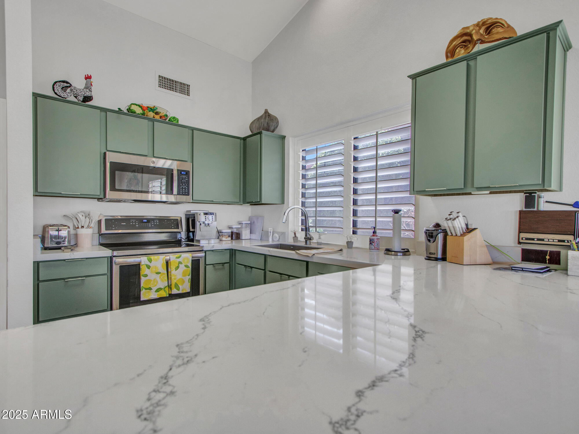 9343 West Escuda Drive Peoria, AZ 85382 - Photo 14 of 51 a kitchen with stainless steel appliances wooden cabinets a stove and a sink