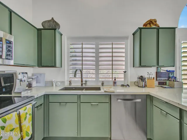 a kitchen with stainless steel appliances a dining table and chairs