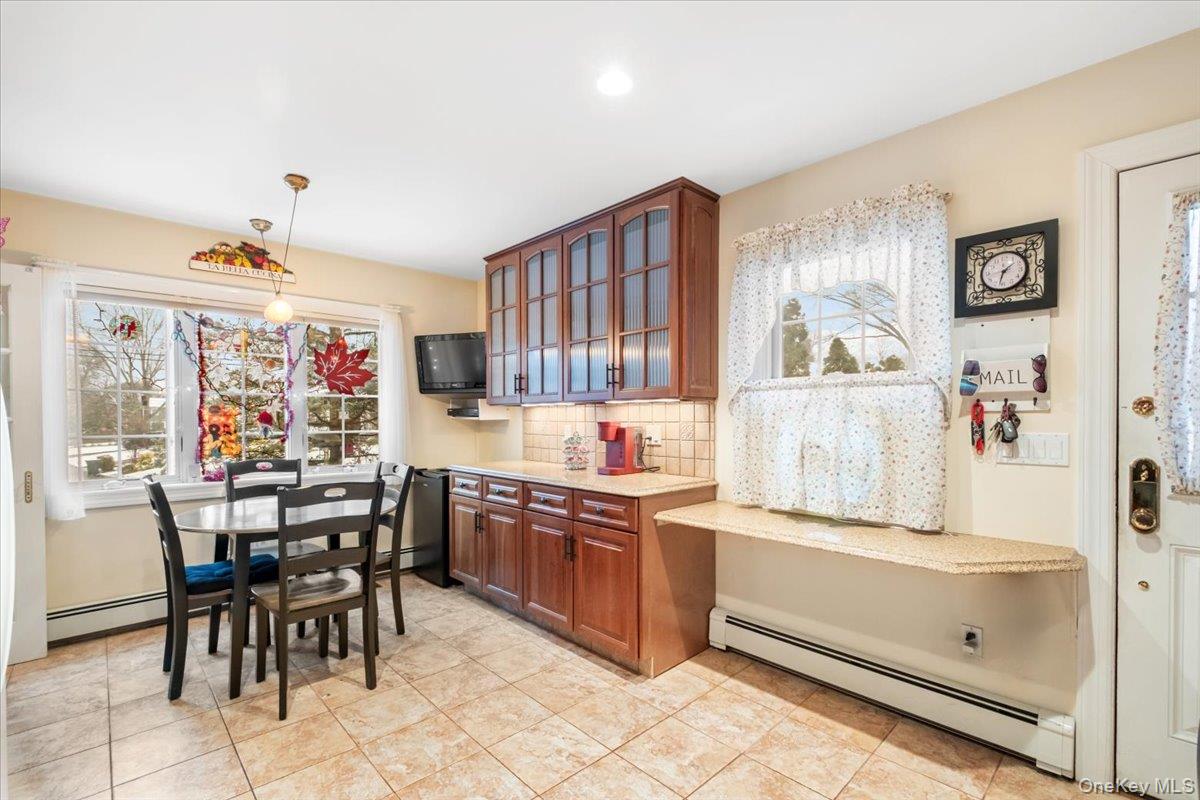 149 Hilburn Road Scarsdale, NY 10583 - Photo 4 of 41 a kitchen with stainless steel appliances kitchen island granite countertop a table chairs in it and wooden floors