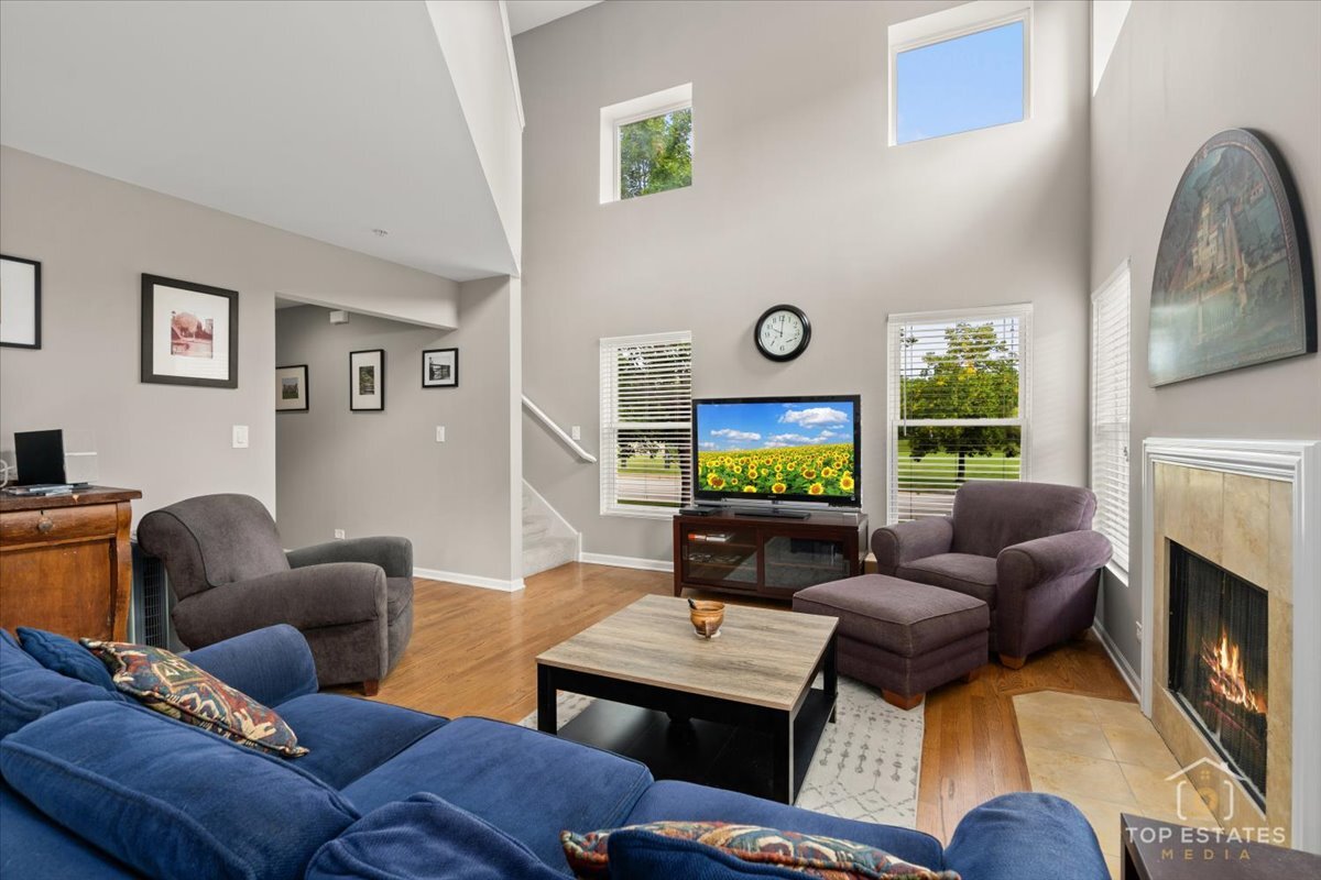 1651 Pauline Circle, Unit 1651 Mundelein, IL 60060 - Photo 11 of 42 a living room with furniture a fireplace and a flat screen tv