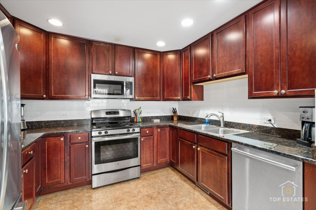 1651 Pauline Circle, Unit 1651 Mundelein, IL 60060 - Photo 17 of 42 a kitchen with wooden cabinets stainless steel appliances and a sink