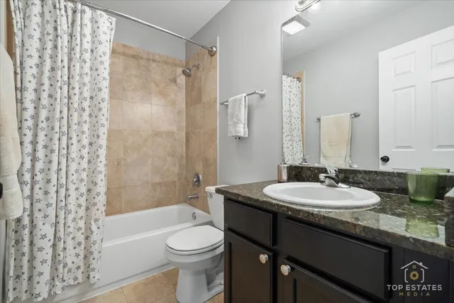 a bathroom with a granite countertop sink toilet a mirror a shower and a bathtub