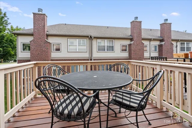 a view of a roof deck with table and chairs
