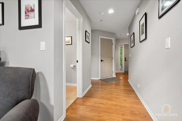 a view of a hallway with wooden floor and furniture