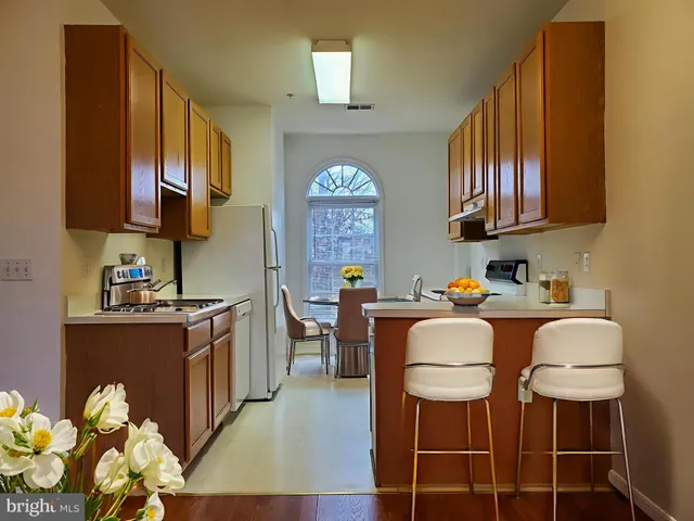a living room with stainless steel appliances granite countertop furniture a fireplace a rug and a window
