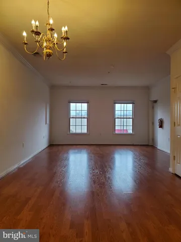 a view of a room with wooden floor and chandelier