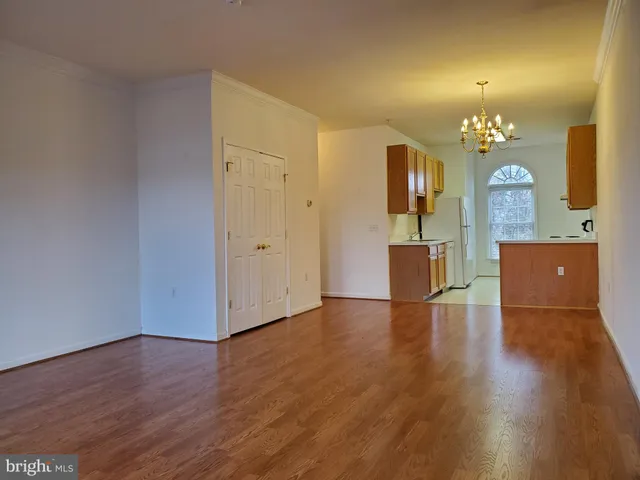 an empty room with wooden floor and mirror