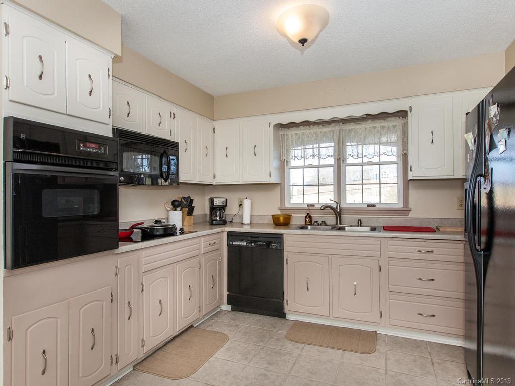 2533 Iron Duff Road Waynesville, NC 28785 - Photo 14 of 35 a kitchen with granite countertop white cabinets and sink