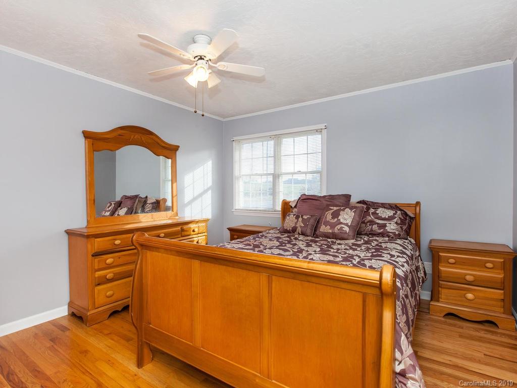2533 Iron Duff Road Waynesville, NC 28785 - Photo 18 of 35 a bed room with a bed and a chandelier