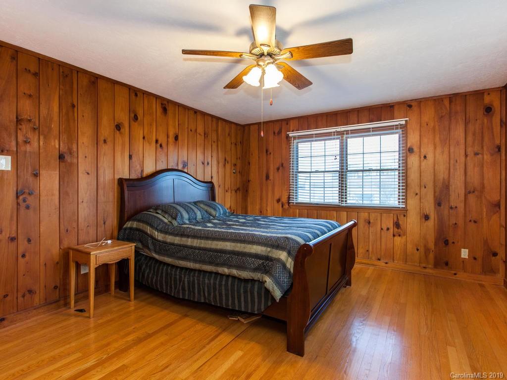 2533 Iron Duff Road Waynesville, NC 28785 - Photo 22 of 35 a bedroom with a bed and a chandelier