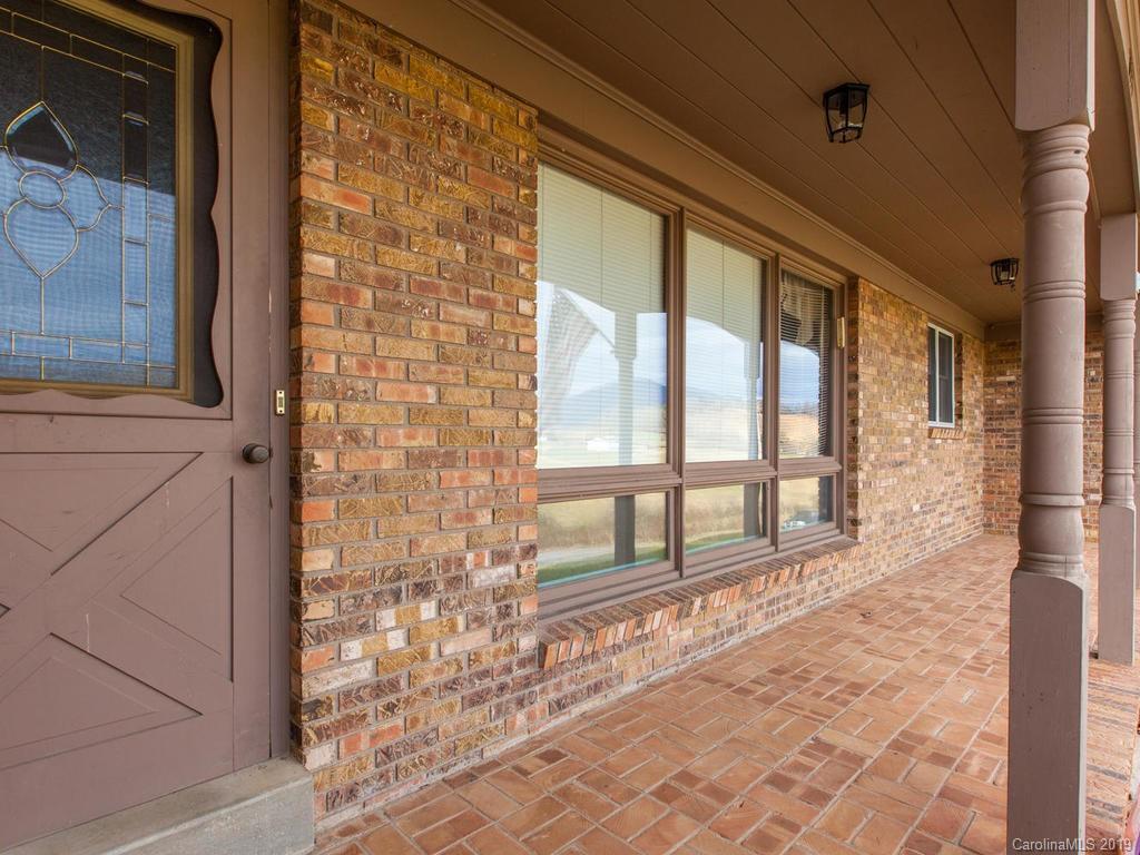 2533 Iron Duff Road Waynesville, NC 28785 - Photo 7 of 35 a view of a porch with a floor to ceiling window and wooden floor